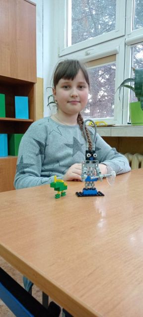 dziewczynka z klasy 4a ze swoją budowlą z klocków lego