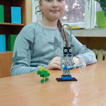 dziewczynka z klasy 4a ze swoją budowlą z klocków lego